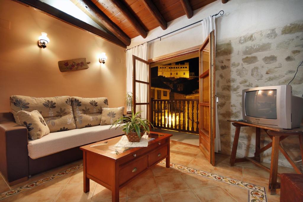 sala de estar con sofá y TV en Apartamentos Santa Agueda, en Valderrobres