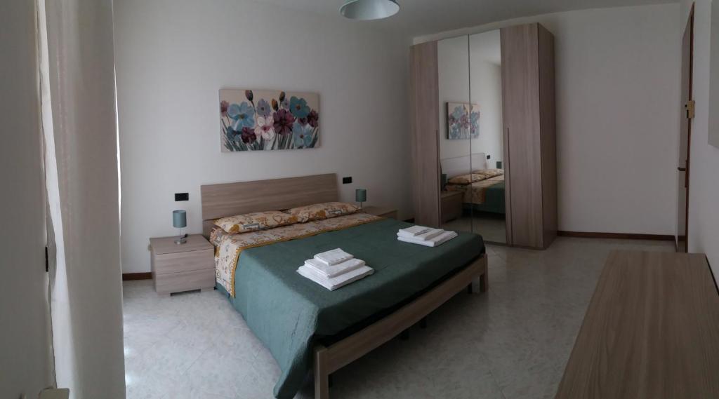 a bedroom with a bed with a green comforter at Villa Susy in Desenzano del Garda