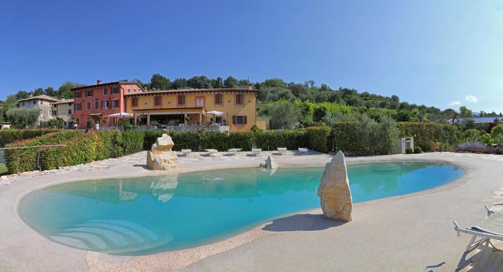 a swimming pool in a yard with a house in the background at La Zerla in Bardolino