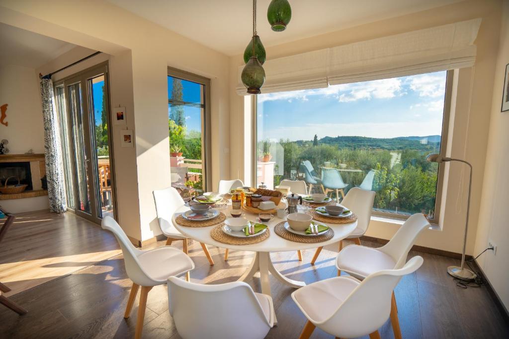comedor con mesa y sillas y ventana grande en Villa Rodi, en Katastárion
