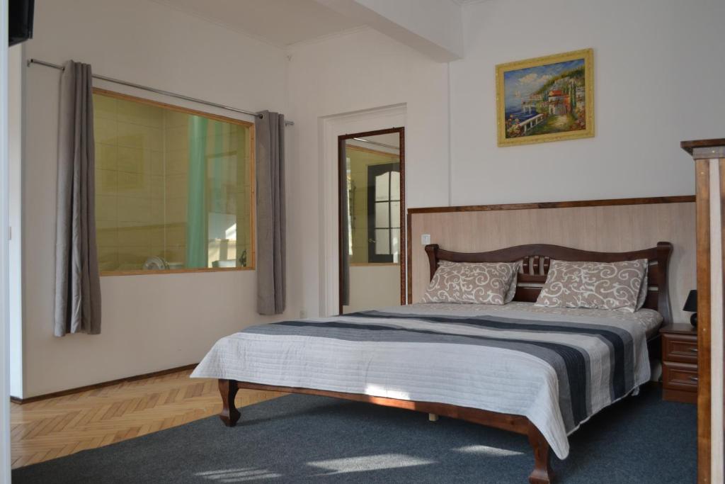 Un dormitorio con una cama y una ventana grande. en ART ApartmenT, en Ternopilʼ