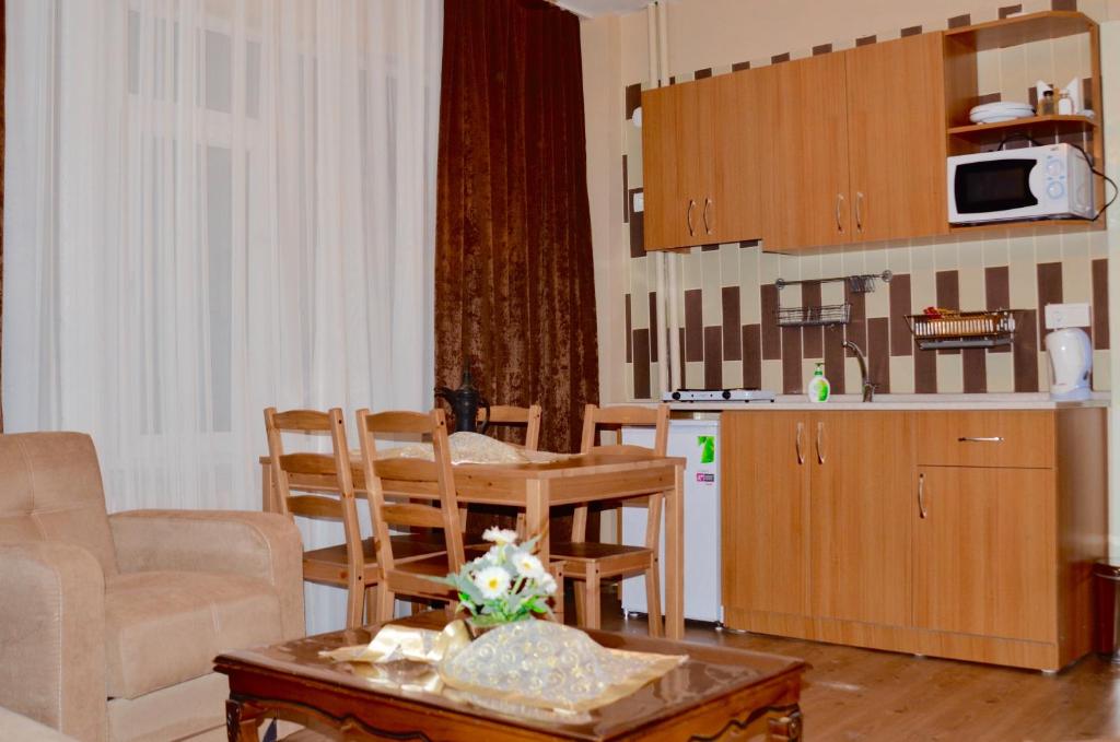 a kitchen and a living room with a table and chairs at Elit Apartments and Suites Corlu in Çorlu