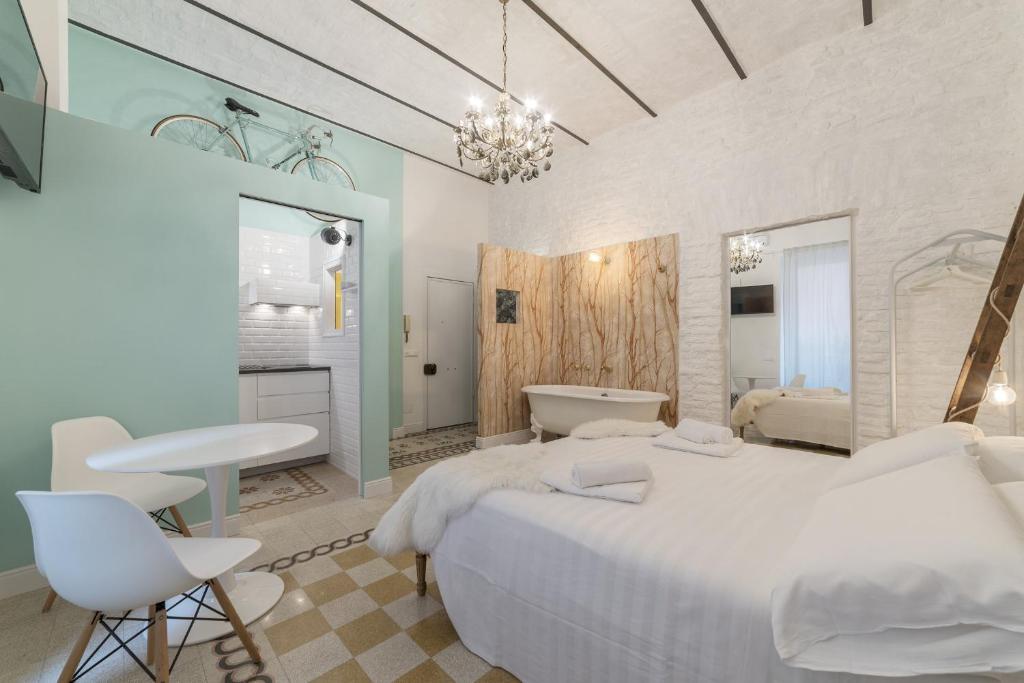 een witte slaapkamer met een groot bed en een badkamer bij Romantic Vintage Colosseum Suite in Rome