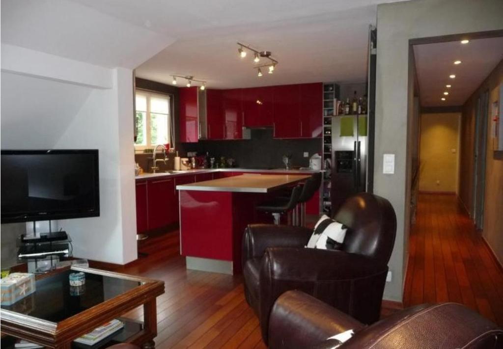 uma cozinha com armários vermelhos e cadeiras de couro em PETIT YATOU APPART' em Cauterets