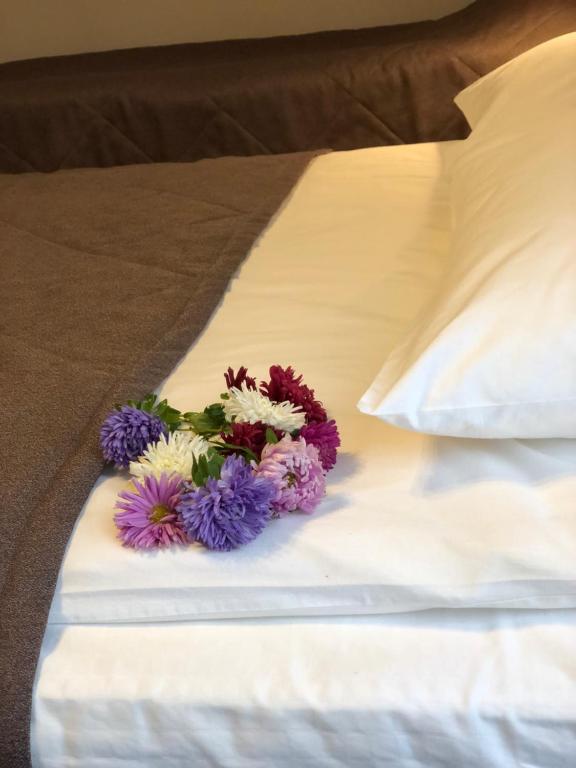 a bouquet of flowers sitting on a bed at Hotel Astra in Nizhny Novgorod