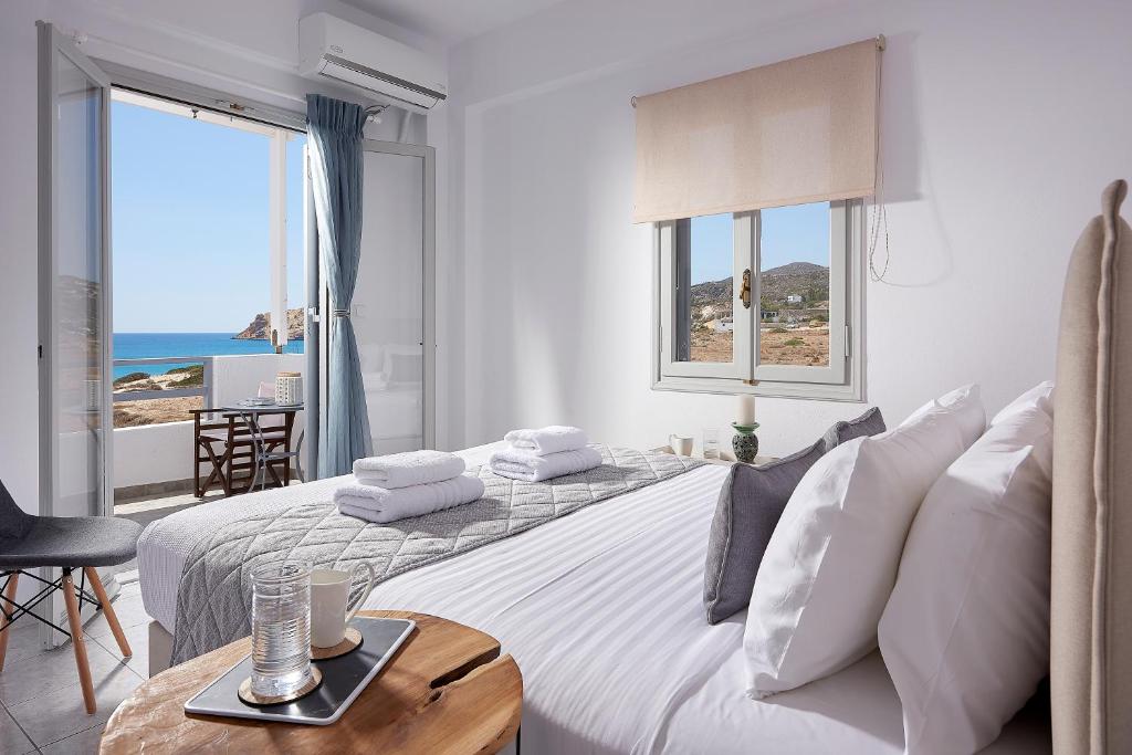 a bedroom with a bed with a view of the ocean at Muses Rooms Milos in Provatas