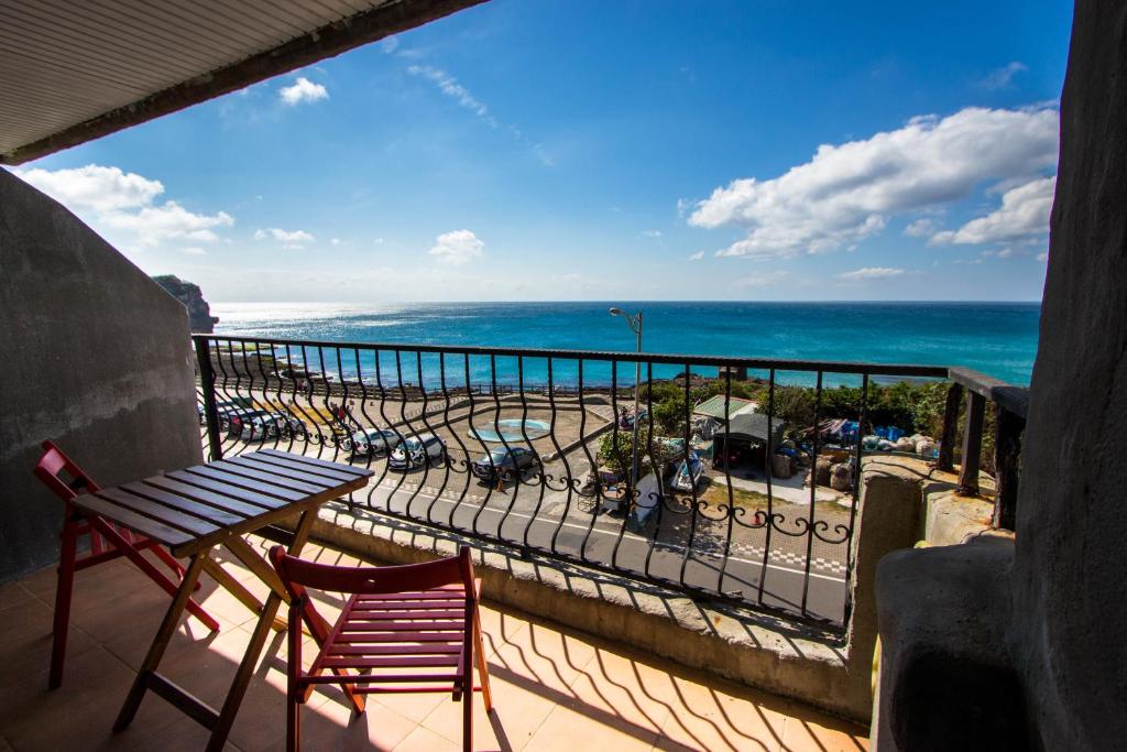 balcón con mesa, sillas y vistas al océano en 710 House, en Eluan