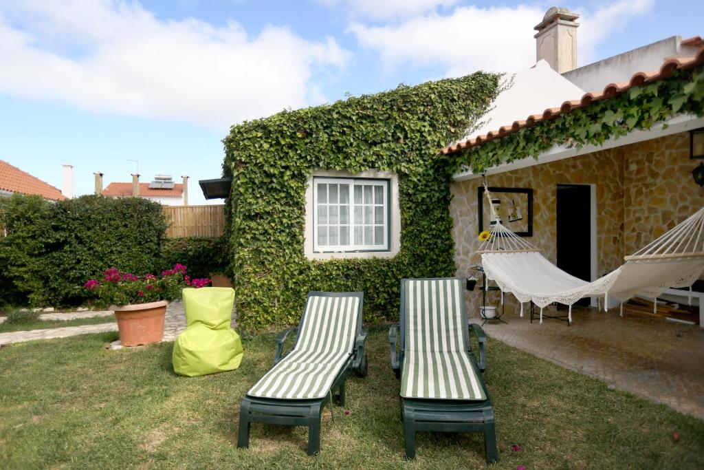 エリセイラにあるLike-home Casa da Heraの家の外に椅子2脚とハンモック