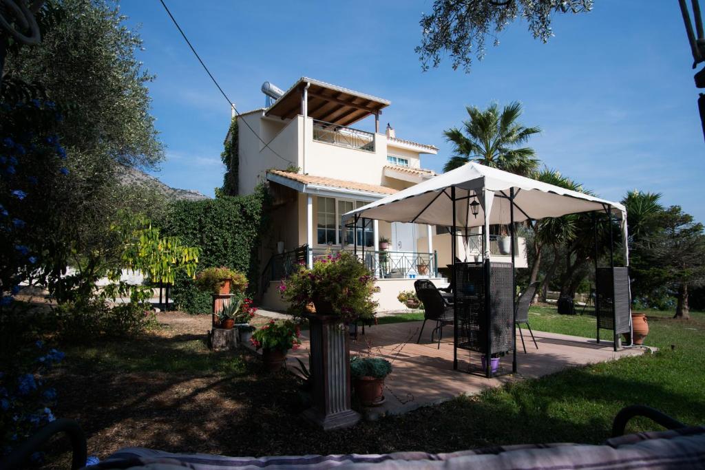 una casa con sombrilla, mesa y sillas en Sunny Garden villa en Platariá