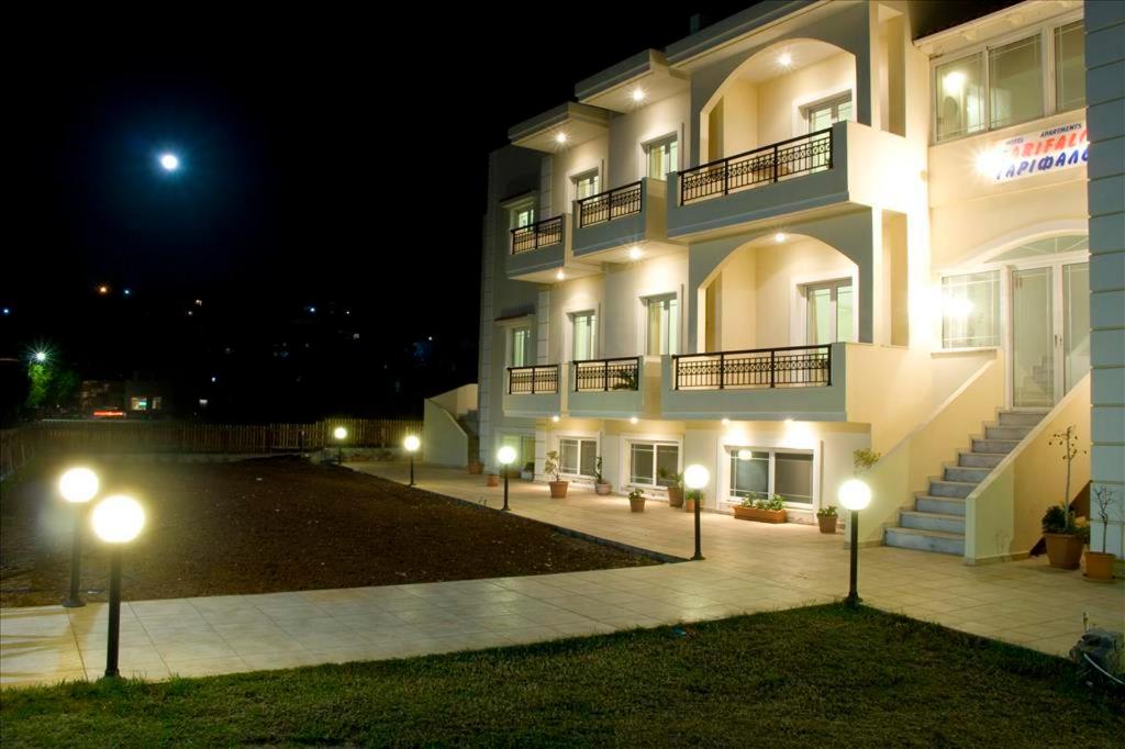 a large building with lights in front of it at night at Garifalo Apartments in Kalyves