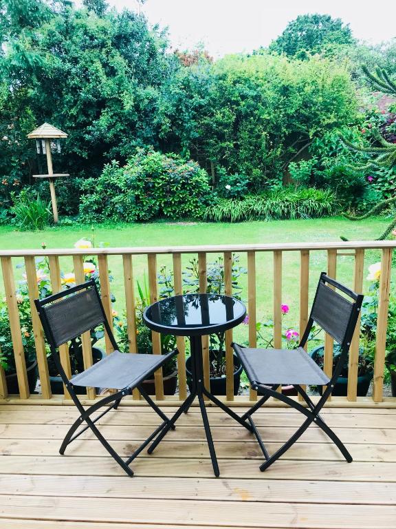dwa krzesła i stół na tarasie w obiekcie Coastal Retreat w mieście Lowestoft