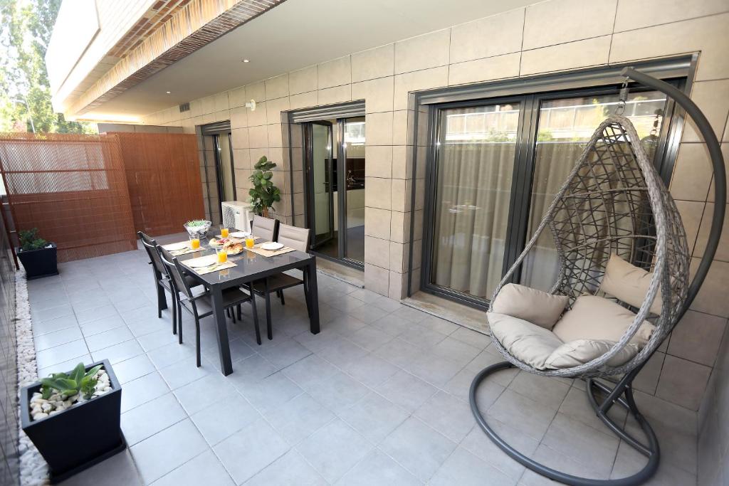 un patio con una mesa y una silla mecedora en Like-home Best Place Apt en Lisboa