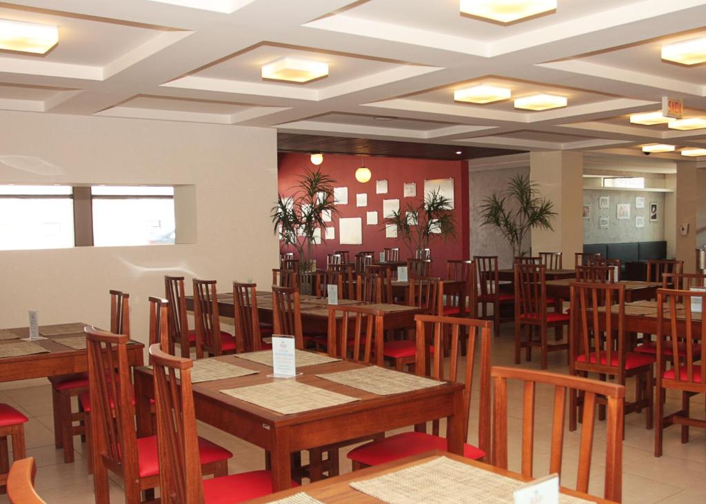 a dining room with wooden tables and chairs at Hotel Raul's in Gaspar