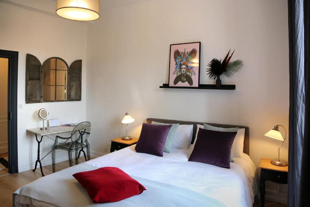 a bedroom with a bed with a red pillow on it at Troisième Droite in Cahors