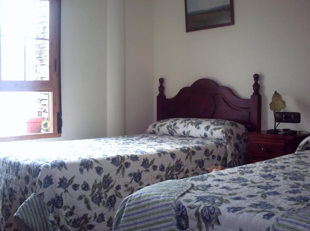 a bedroom with two beds and a window at Casa Rural La Breña in Talaván