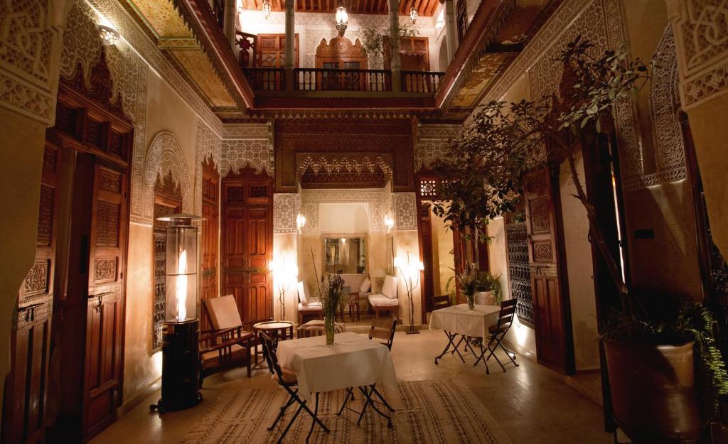 a room with tables and chairs in a building at Riad Dar Zaya in Marrakesh
