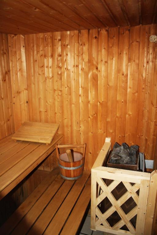 a wooden sauna with a bench and a basket in it at Hôtel Panorama in Munster
