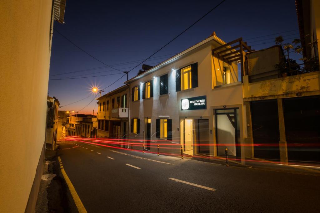 una strada di città vuota di notte con un edificio di Apartments Madeira City Center a Funchal