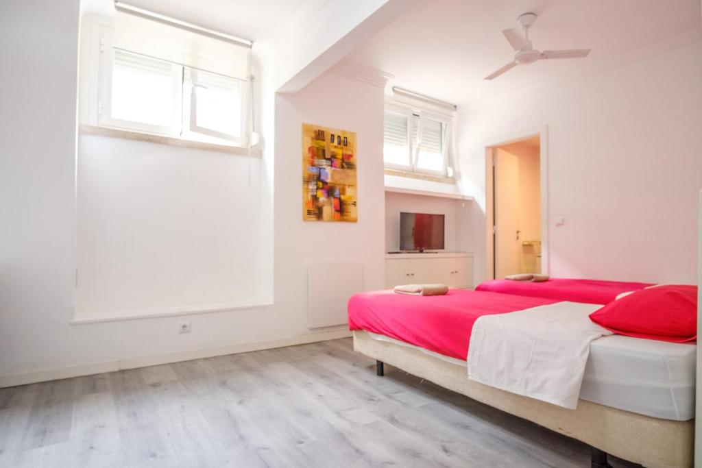 a bedroom with two beds and a ceiling fan at Tagus 5 Colours Suites in Algés