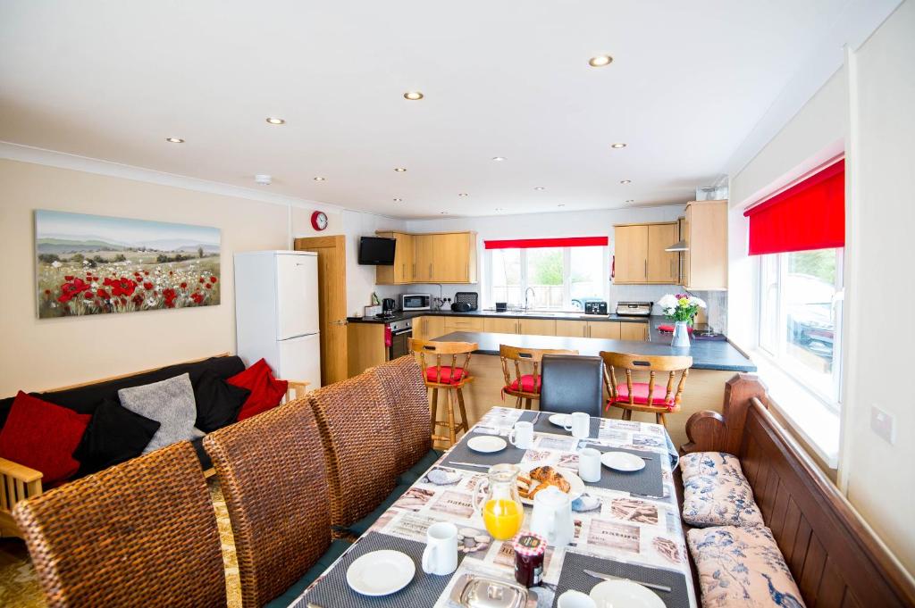 a dining room and kitchen with a table and chairs at ROUND PARK- Private and spacious family bungalow with parking in Laugharne