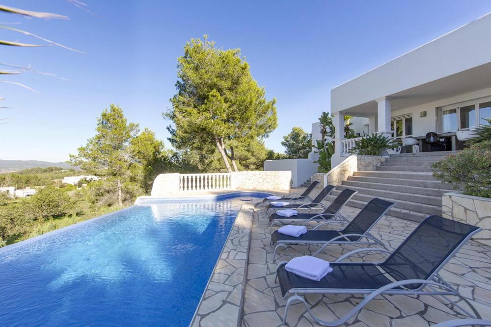 a villa with a swimming pool and lounge chairs at DOS MONOS in San Antonio Bay