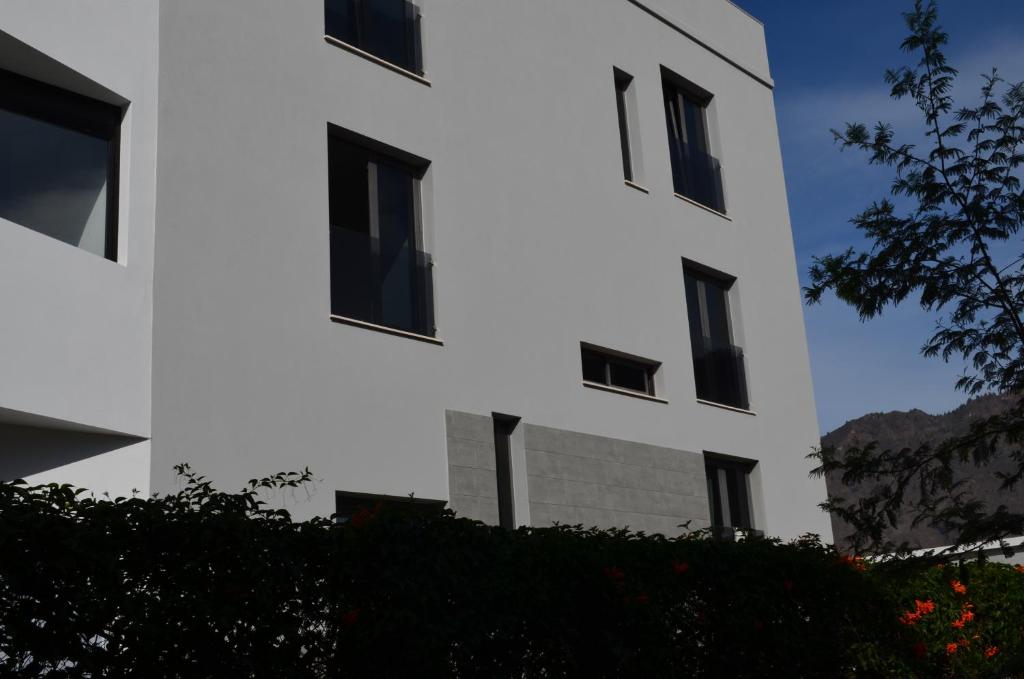 a white building with black windows on it at Apartamento Sauco in Los Llanos de Aridane