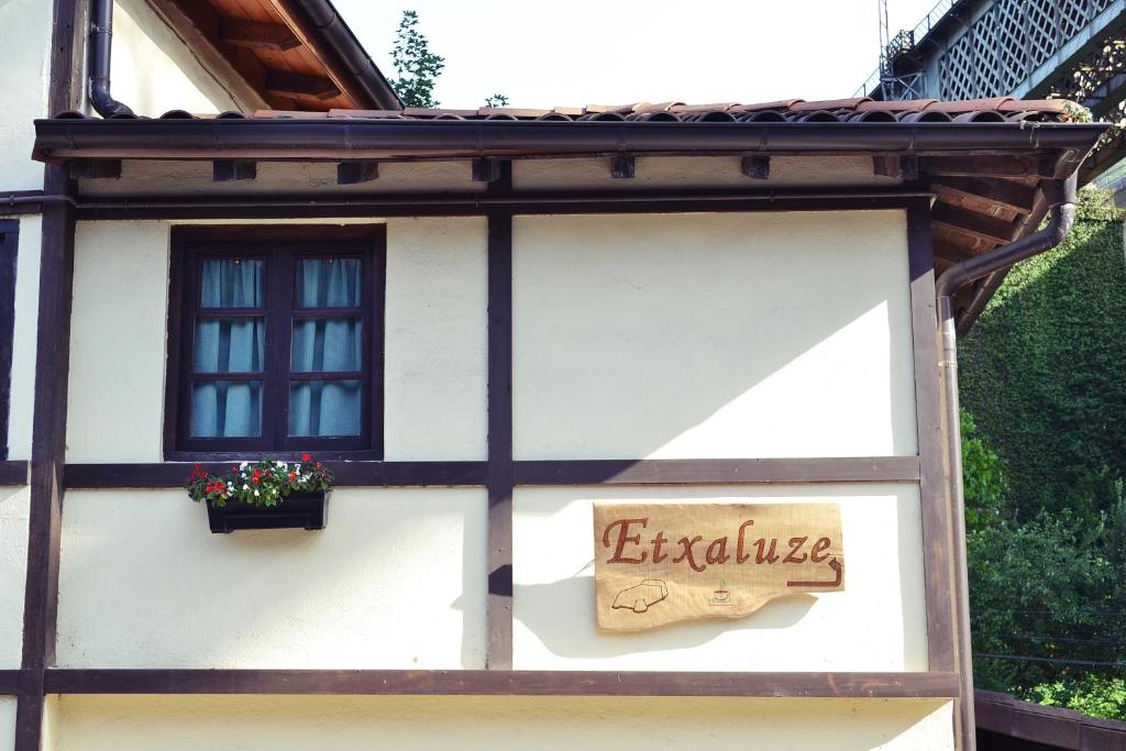 un panneau sur le côté d'une maison dans l'établissement Casa Rural Etxaluze, à Ormáiztegui