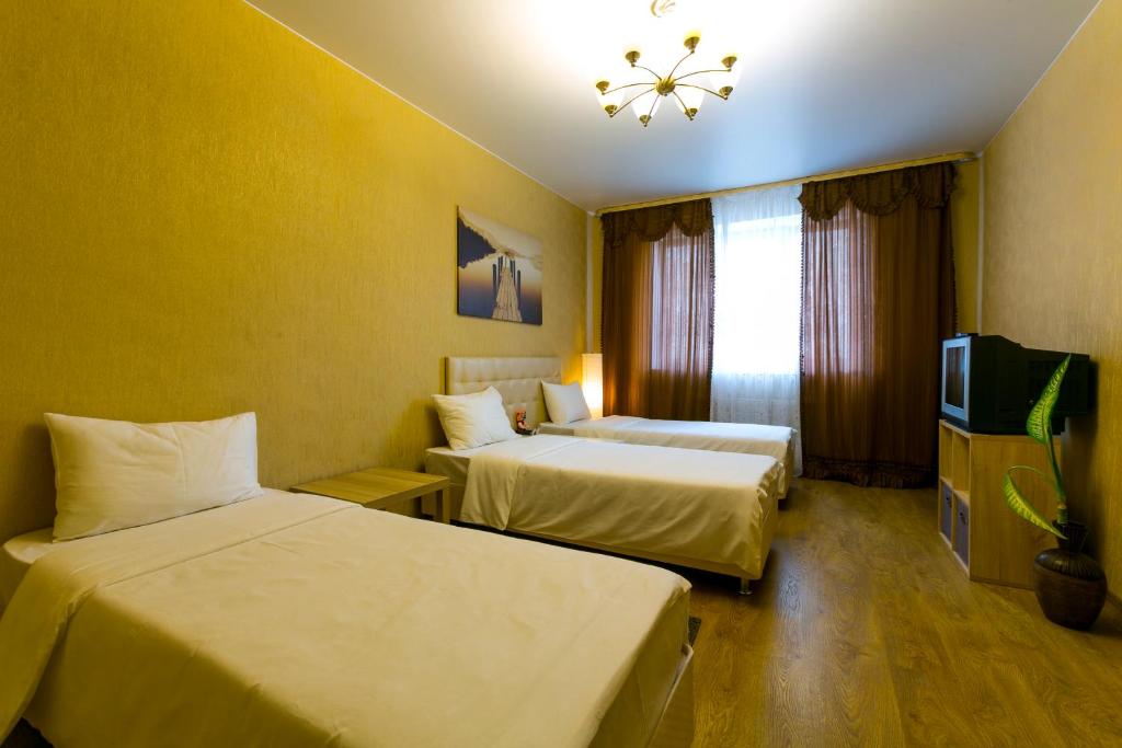 ポドリスクにあるDobrye Sutki - Komandirovka 6+のベッド2台とテレビが備わるホテルルームです。