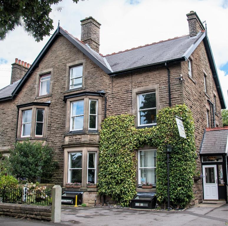 an old brick house with ivy at The Old Manse in Buxton