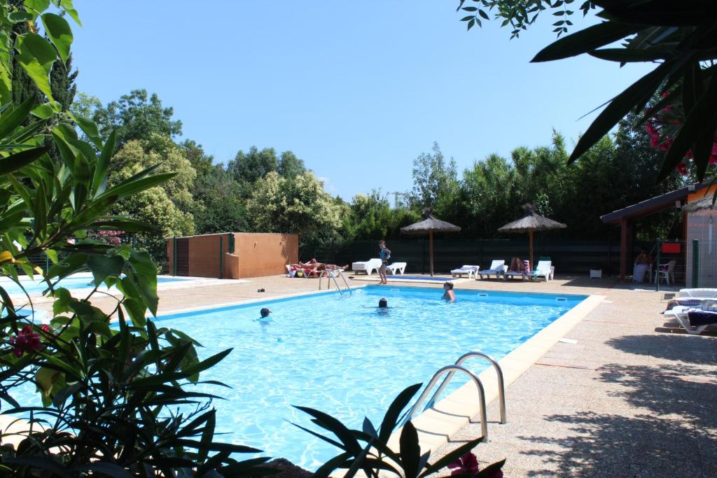 una gran piscina con gente en el agua en Camping de la Chapelette en Saint-Martin-de-Crau