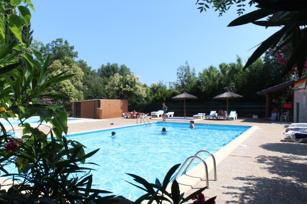 a large swimming pool with people in the water at Camping de la Chapelette in Saint-Martin-de-Crau