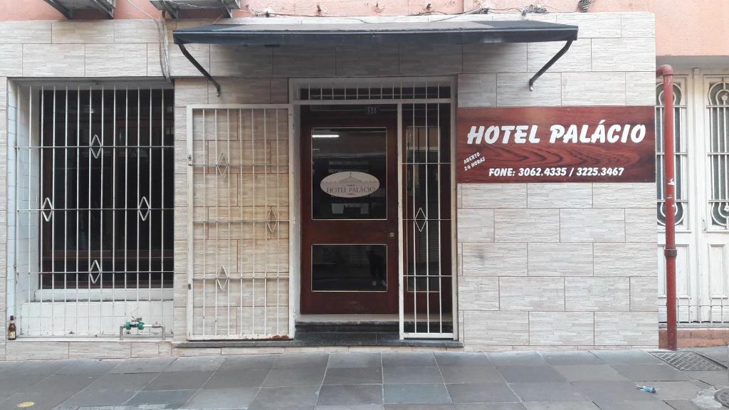 un edificio de hotel con una puerta y un cartel en él en Hotel Palácio - Próx ao Hospital Santa Casa, en Porto Alegre