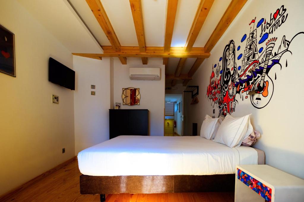 sypialnia z łóżkiem i ścianą pokrytą graffiti w obiekcie House Petit Lusa w Lizbonie