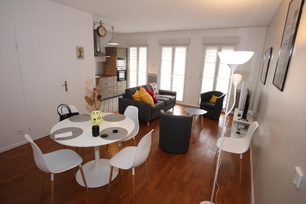 un salon avec une table et des chaises blanches dans l'établissement App 3 pièces hyper proche Disney, refait à neuf, à Serris