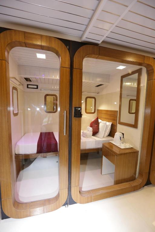 a room with a bedroom and a bed in a boat at Qubestay Airport Capsule Hotel & Hostel in Mumbai