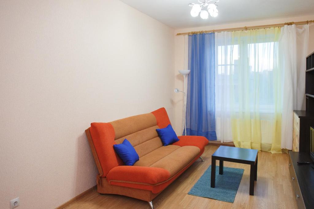 ペトロザヴォーツクにあるKarjala Home on Kazarmenskayaのリビングルーム(オレンジ色のソファ、青い枕付)