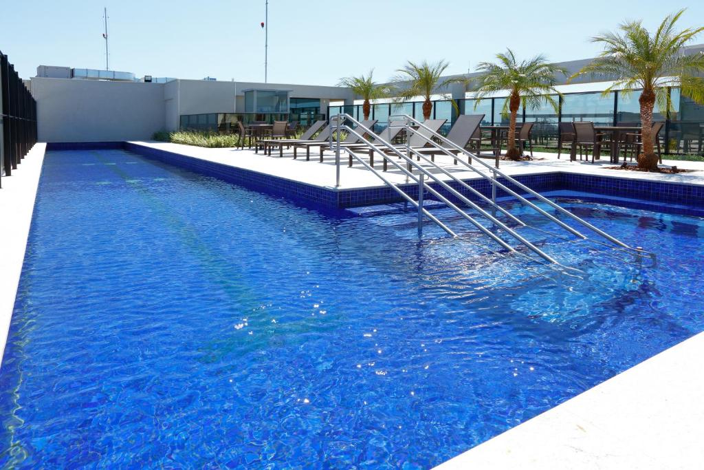 a swimming pool with a slide in the middle of it at Royal Palm Tower Anhanguera in Campinas