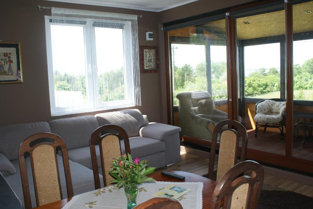 salon z kanapą, stołem i krzesłami w obiekcie Agrodomki Okej -Dom Koko w mieście Gardna Wielka