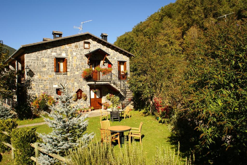 una casa in pietra con un tavolo e sedie di fronte di Casa Martin Ordesa a Sarvisé