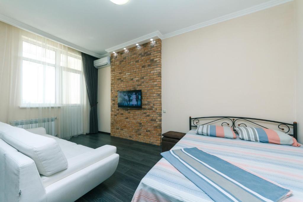 a bedroom with two beds and a brick wall at 1к Люкс на Жилянская 118 in Kyiv