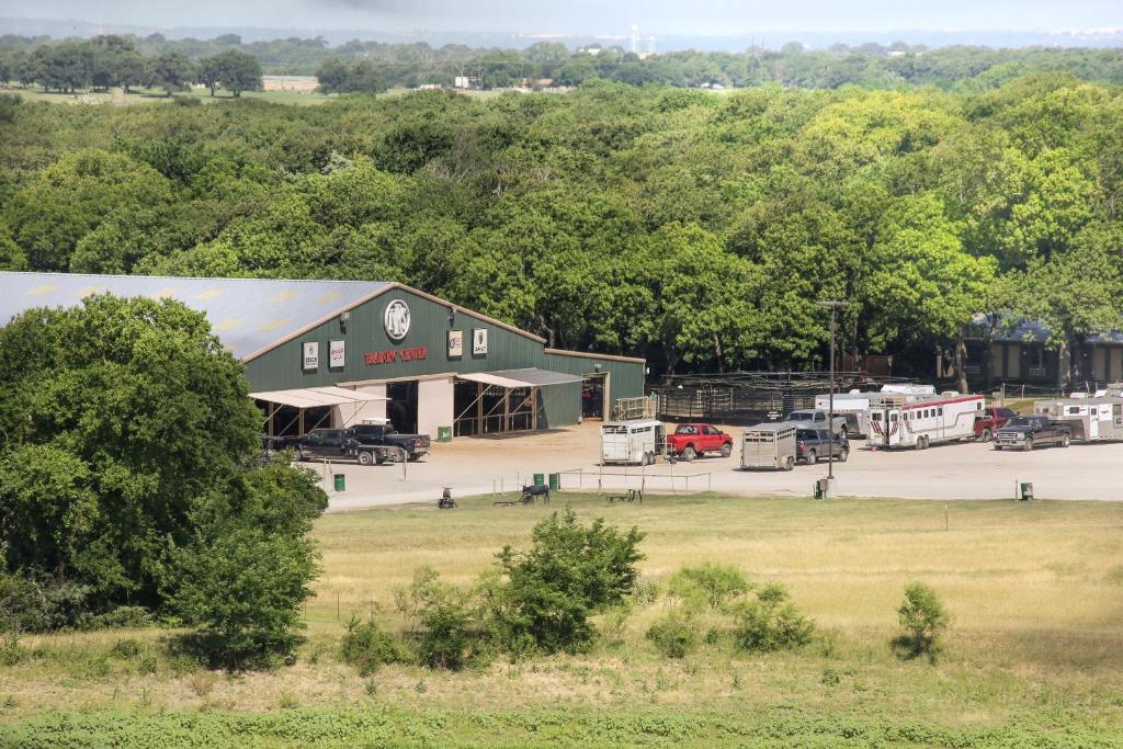 un granero verde grande con coches aparcados en un aparcamiento en NRS Event Center & Guest Ranch, en Decatur