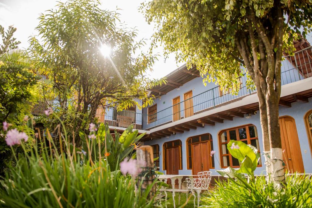 ein weißes Haus mit Orangentüren und Bäumen in der Unterkunft Hotel Casa de las Fuentes in Antigua Guatemala