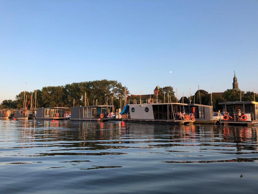 a group of boats are docked in the water at Hausboot- Domy na wodzie - Houseboat Porta Mare in Kamień Pomorski