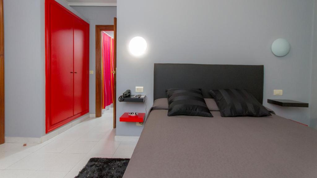 1 dormitorio con 1 cama grande y puerta roja en Pensión La Mar en Castro-Urdiales