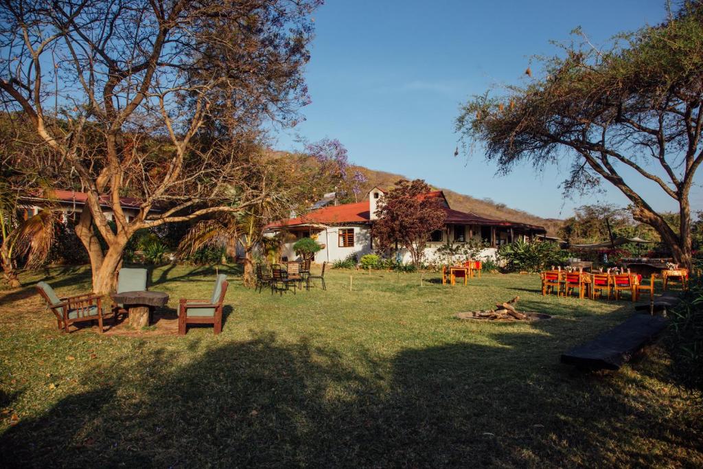 un patio con mesas y sillas frente a un edificio en Utengule Coffee Lodge, en Utengule