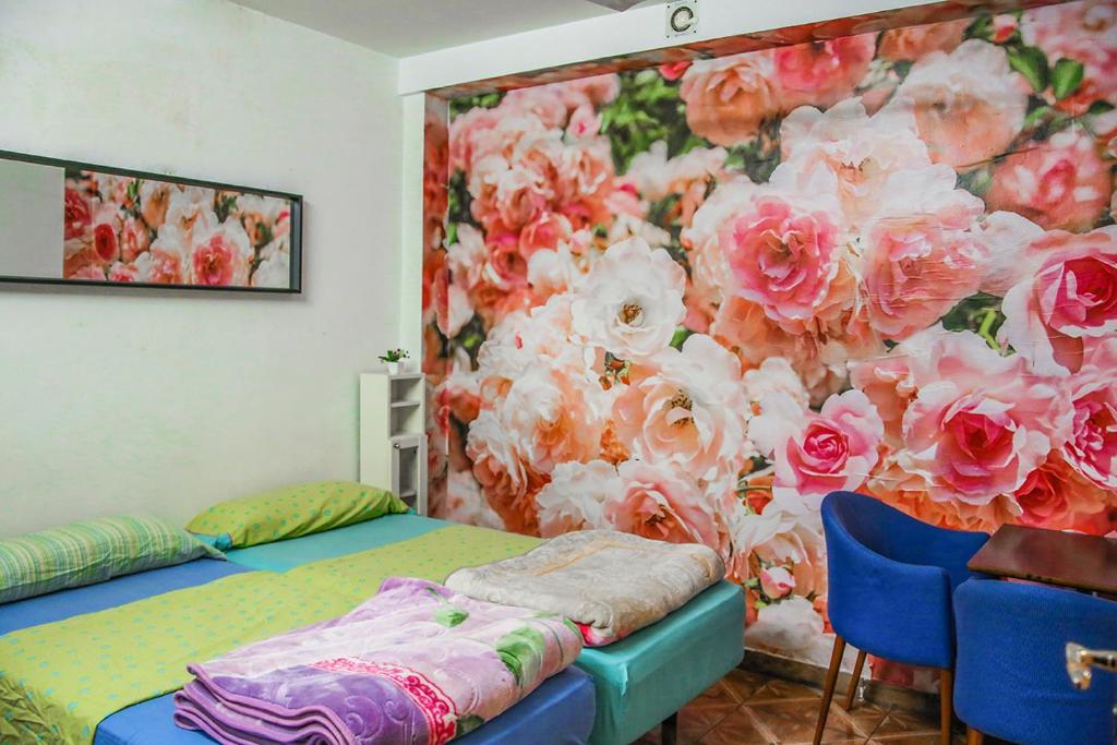 una habitación con 2 camas y una pared con flores en Hostal Ideal Sants, en Barcelona