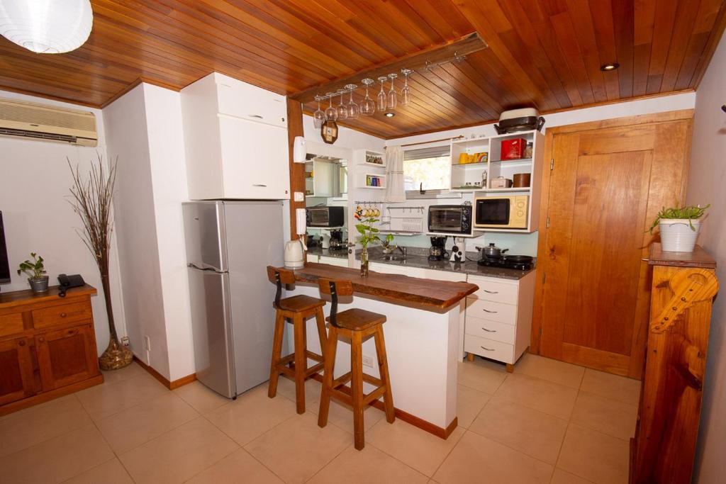 una cocina con electrodomésticos blancos y techos de madera. en Departamento céntrico San Martín de los Andes en San Martín de los Andes