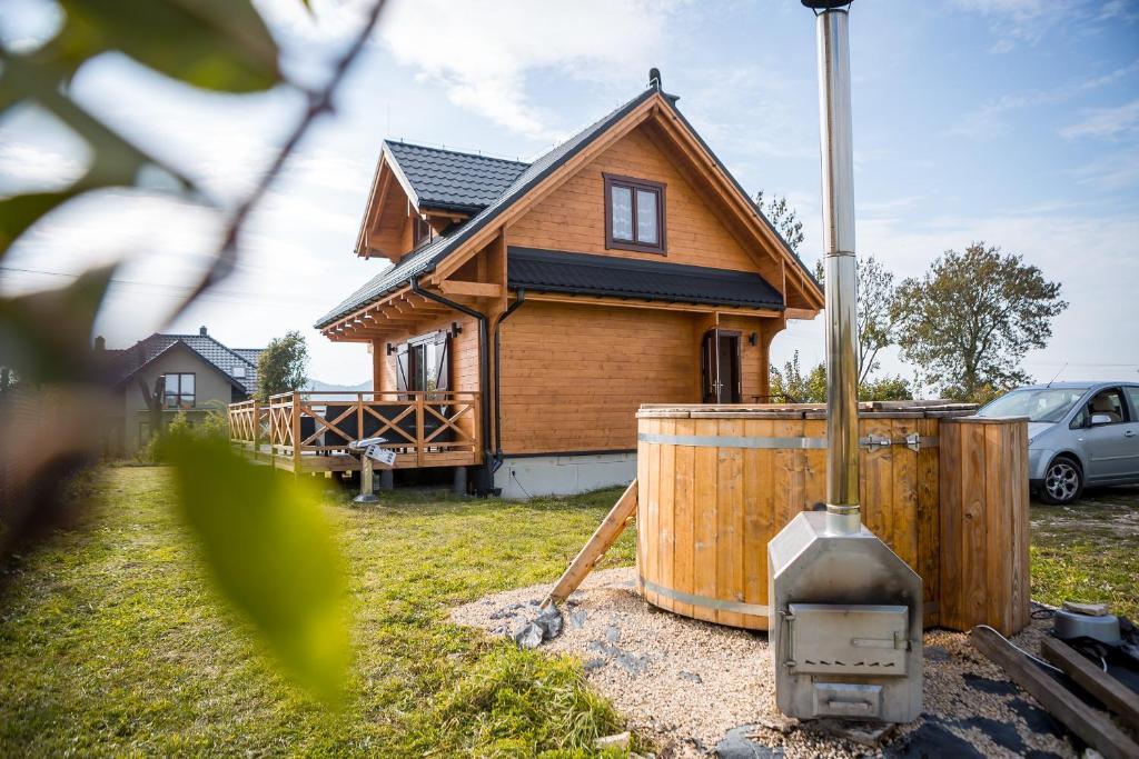 una casa de madera con un tanque delante en Na Dworosku, en Golczowice