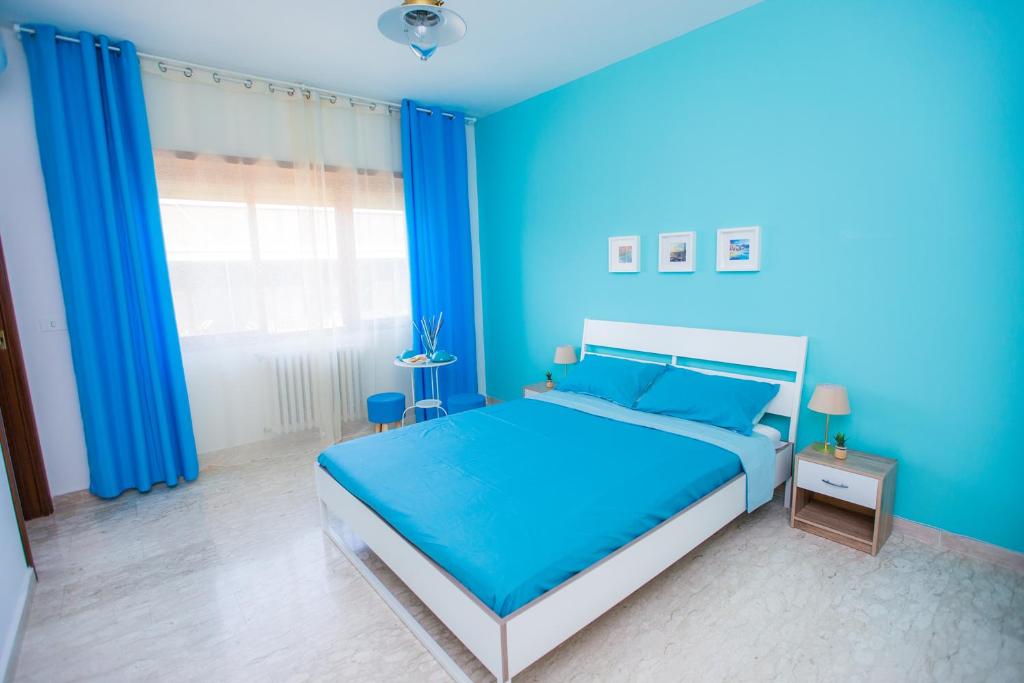 a blue bedroom with a bed and a window at Quelli della via Gluck in Rome