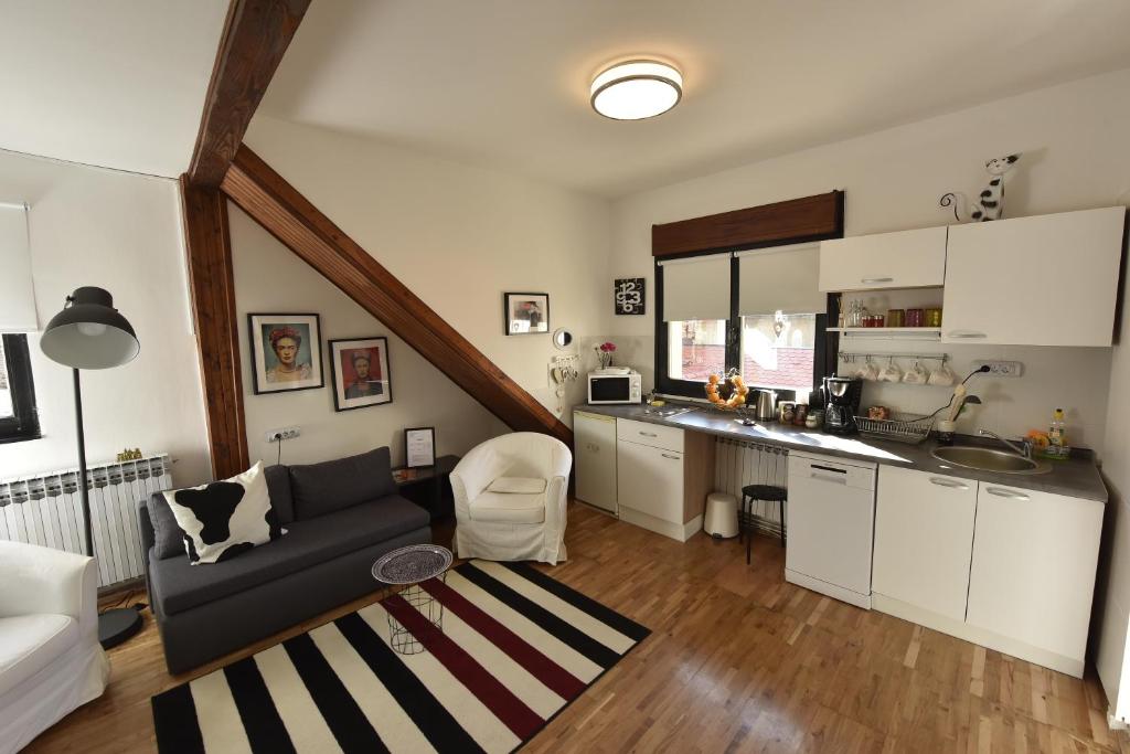 ein Wohnzimmer mit einem Sofa und einer Küche in der Unterkunft Apartments ZAGREB TALES in Zagreb